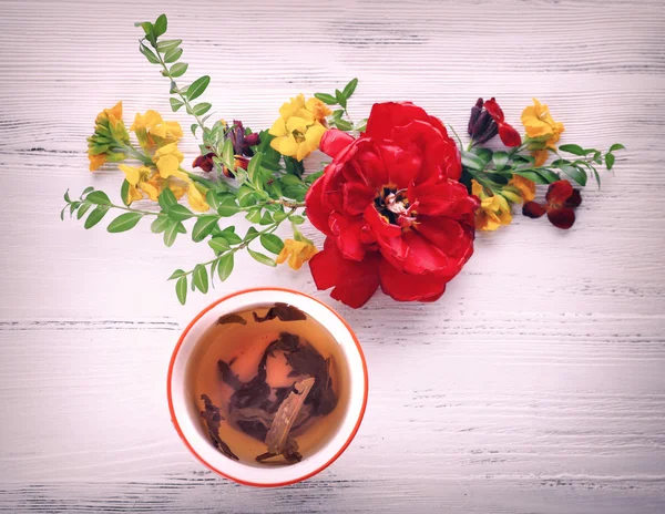 Tasse Tee mit schönen Blumen — Stockfoto