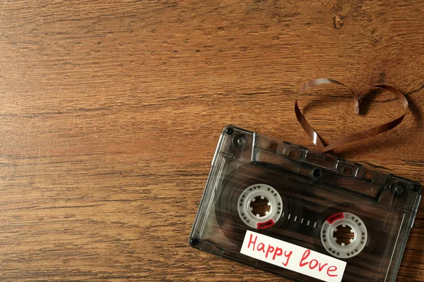 Retro audio cassette with tape in shape of heart — Stock Photo, Image