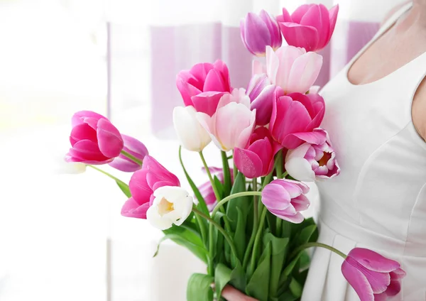 Junge Frau hält Tulpen in der Hand — Stockfoto