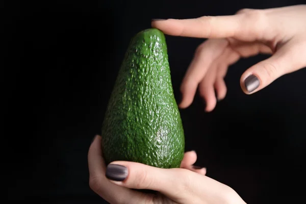 Female hands holding avocado — Stock Photo, Image
