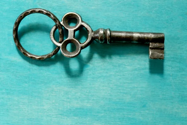 Key on turquoise background — Stock Photo, Image