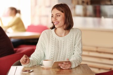 Genç bayan kahve içiyor.