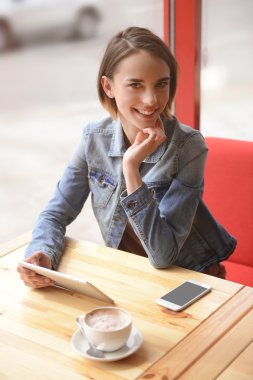 smartphone ile kafede oturan kadın