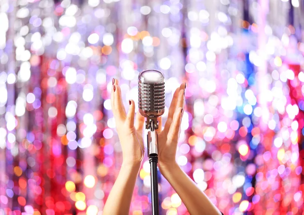 Female hands holding microphone — Stock Photo, Image