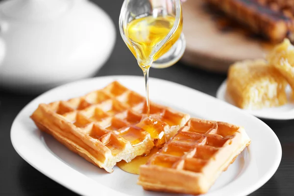 Pouring honey on waffles — Stock Photo, Image