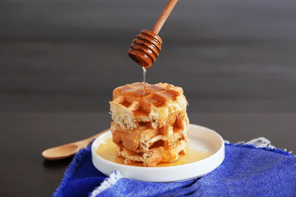 Gieten van honing op wafels — Stockfoto