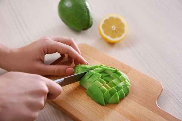 Mujer rebanando aguacate fresco — Foto de Stock