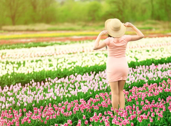 Mujer en campo floreciente de tulipanes — Foto de Stock