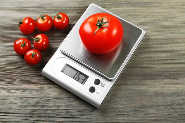 Tomatoes with digital kitchen scales — Stock Photo, Image