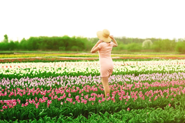 Vrouw op bloeiende gebied van tulpen — Stockfoto