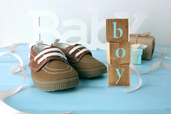 Botas de bebê e cubos de madeira — Fotografia de Stock