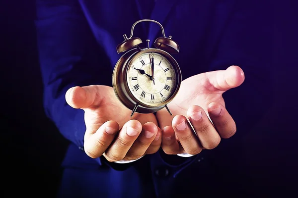 Businessman holding old clock — Stock Photo, Image
