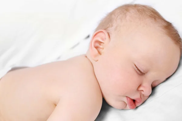 Békés baba alszik egy ágyban — Stock Fotó