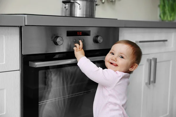 Małe dziecko bawi się kuchenka elektryczna — Zdjęcie stockowe