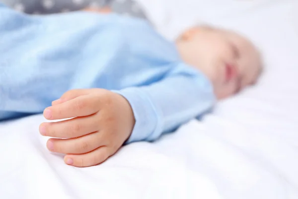 Babyhand auf dem Bett — Stockfoto