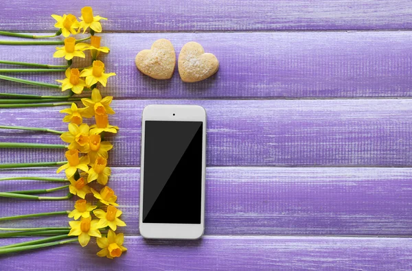 Žluté narcisy a smartphone — Stock fotografie