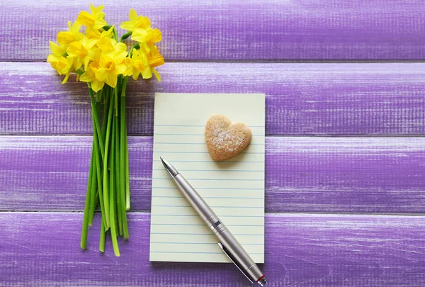 Yellow daffodils and notebook — Stock Photo, Image