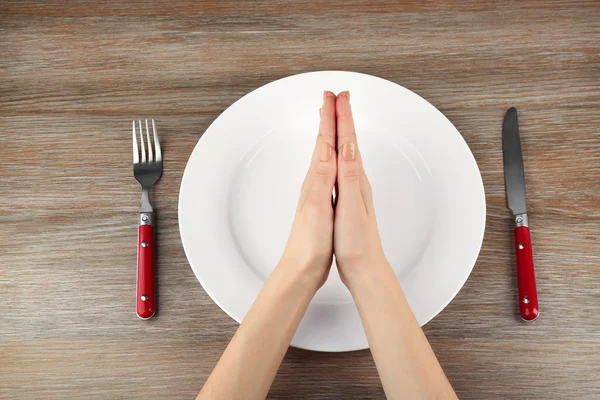 Woman holding hands over plate — Stock Photo, Image