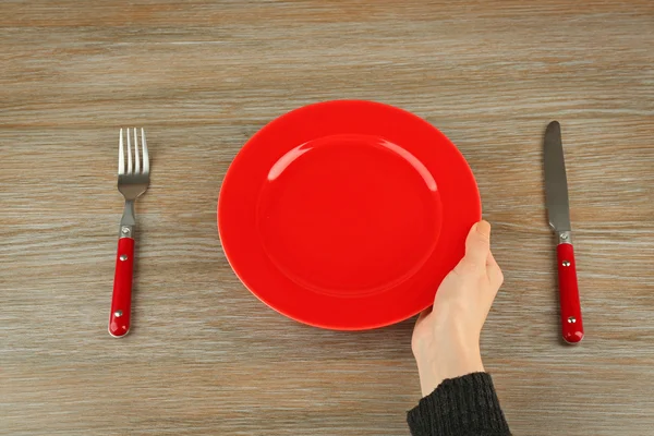 Hand holding empty plate — Stock Photo, Image