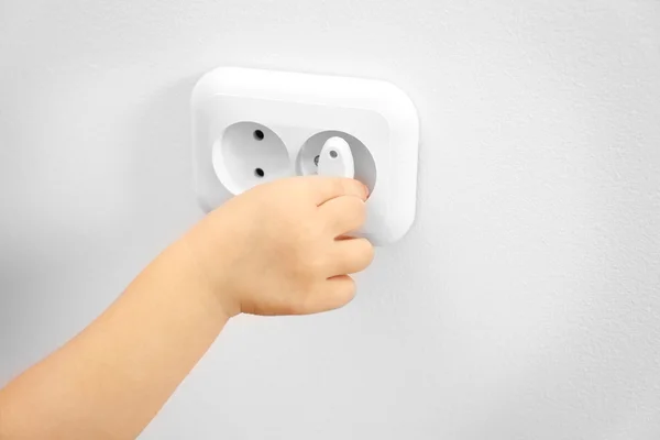 Kind brengen stekker in stopcontact — Stockfoto