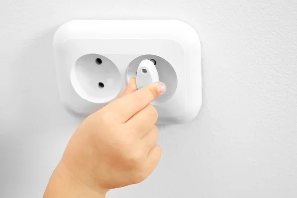 Child putting plug in socket — Stock Photo, Image