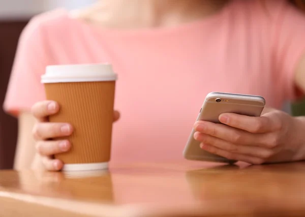 Mulher com café e smartphone — Fotografia de Stock