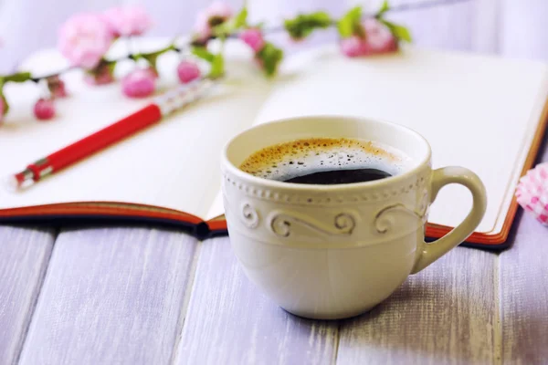 Cup of fresh coffee and notebook — Stock Photo, Image