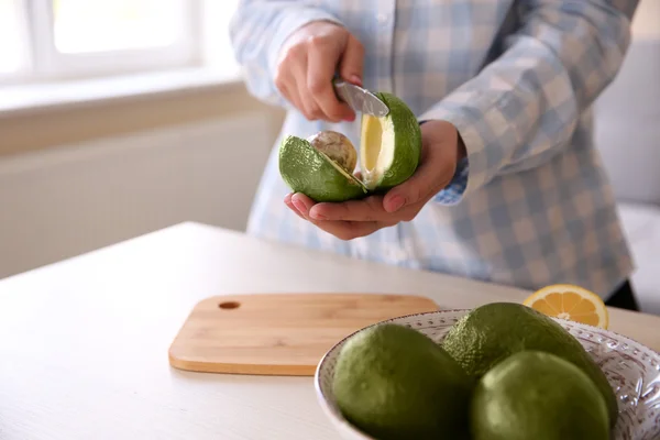 Frau schneidet frische Avocado — Stockfoto