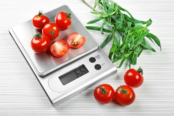 Tomates com balanças de cozinha digital — Fotografia de Stock