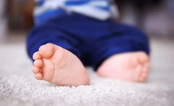Дитячі ноги на килимі — стокове фото