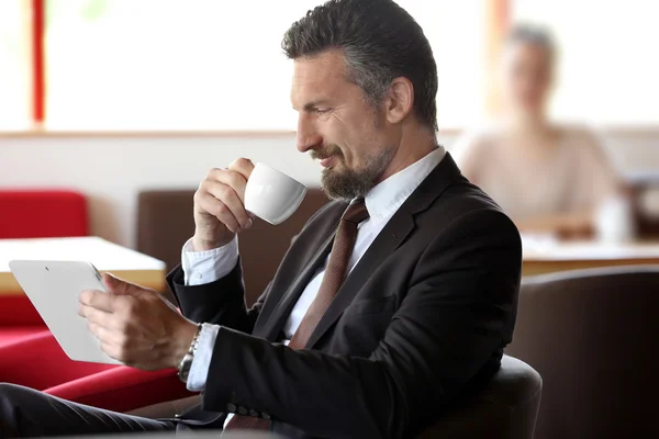 Kahve ve tablet ile kendine güvenen iş adamı — Stok fotoğraf