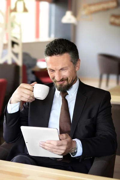 Hombre de negocios seguro con café y tableta — Foto de Stock