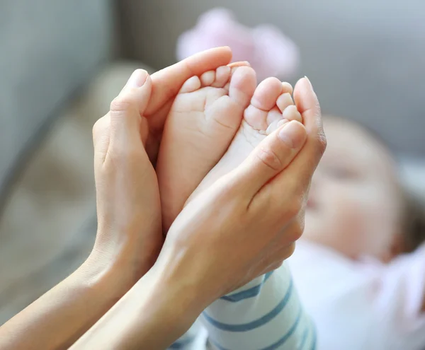 Nainen pitelee vauvan jalat — kuvapankkivalokuva