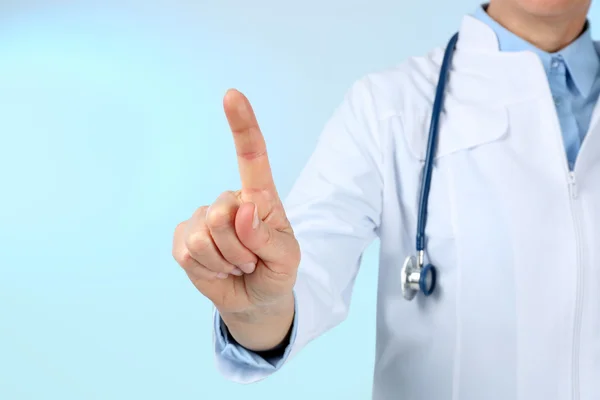 Professional doctor making gesture on blue background — Stock Photo, Image