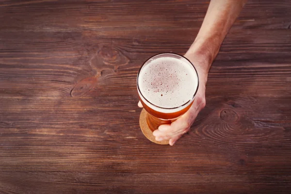 Männliche Hand hält Glas Bier — Stockfoto