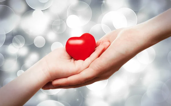 Ruce držící červené srdce — Stock fotografie