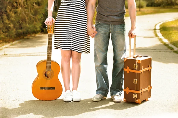 Νέοι ζευγάρι με βαλίτσα και κιθάρα — Φωτογραφία Αρχείου