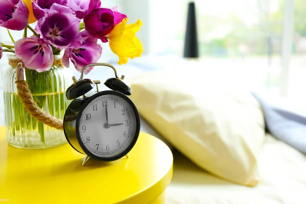 Alarm clock and flower bouquet — Stock Photo, Image