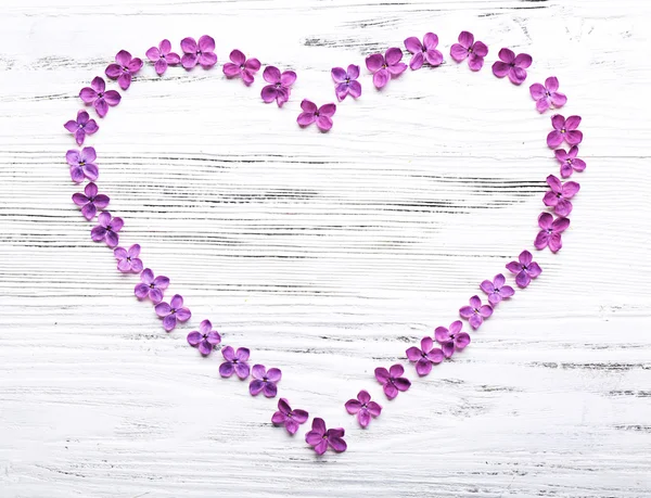 Lila çiçeklerle yapılan kalp — Stok fotoğraf
