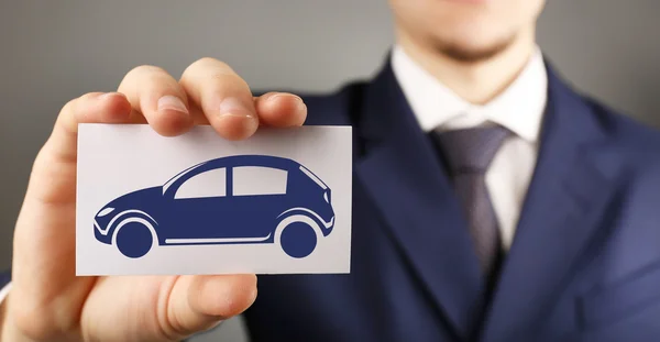 Businessman holding card with car — Stock Photo, Image