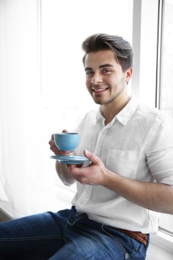 Yakışıklı adam kahve içiyor.