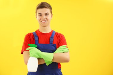 Deterjan sarı arka plan üzerinde tutan adam