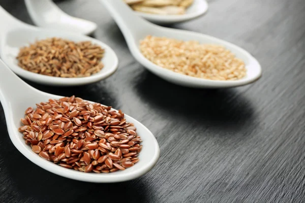 Diferentes tipos de sementes em colheres — Fotografia de Stock