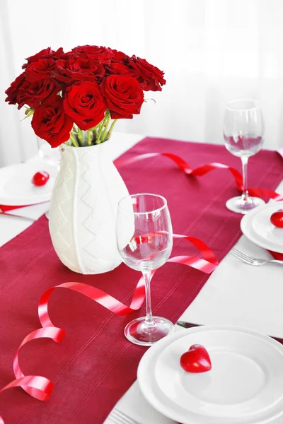 Wazon z czerwonymi różami na świątecznym stole — Zdjęcie stockowe