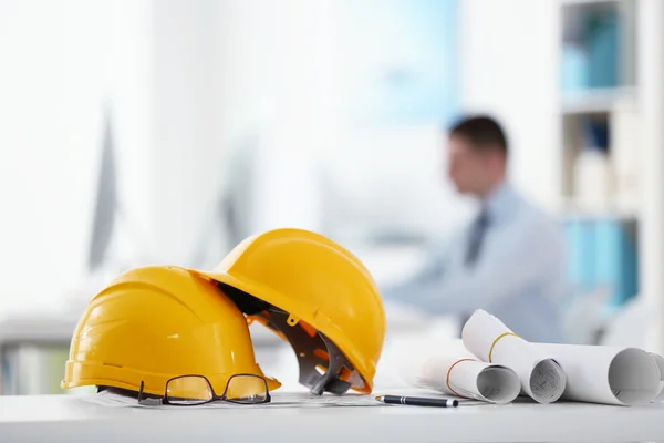 Cascos amarillos en mesa de oficina — Foto de Stock