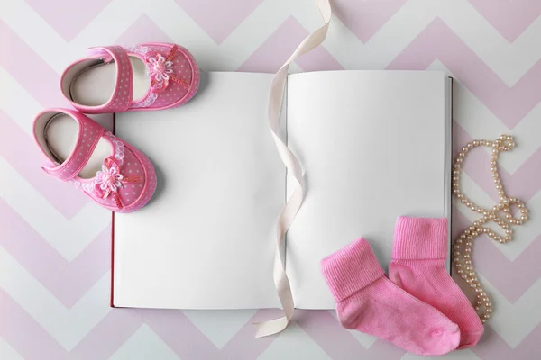Baby boots and notebook — Stock Photo, Image