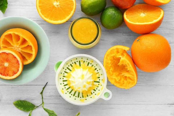 Rebanadas jugosas de naranjas y exprimidor — Foto de Stock