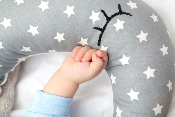 Рука малыша рядом с подушкой — стоковое фото