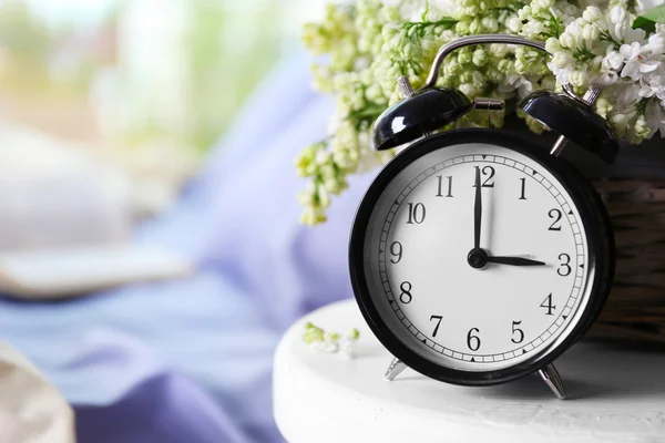 Alarm clock and flower bouquet — Stock Photo, Image