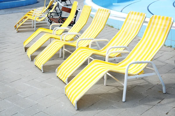 Liegestühle in der Nähe von Schwimmbad — Stockfoto